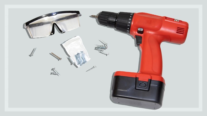 red cordless drill screws and safety glasses